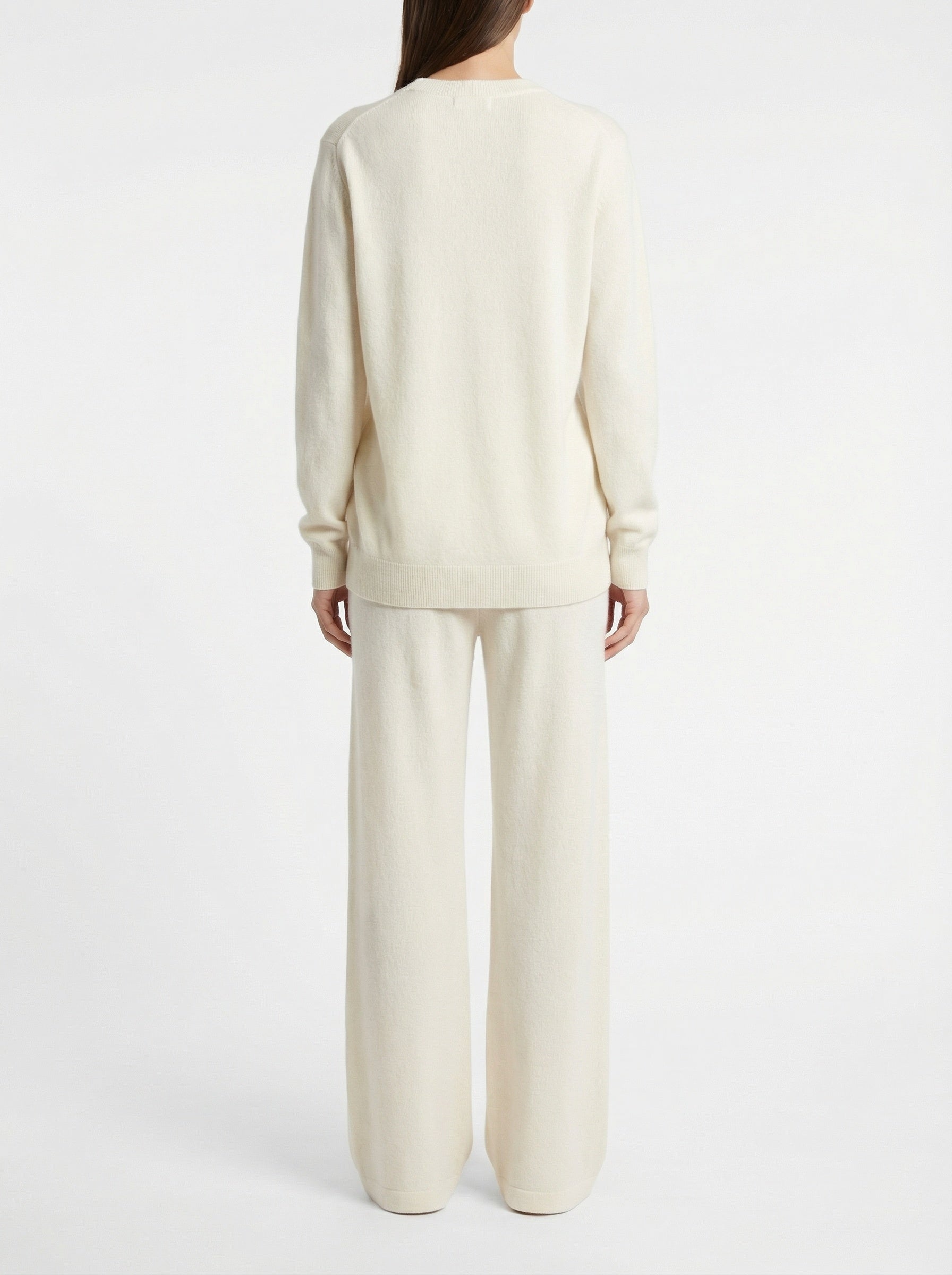 Person wearing a cream-colored outfit on a white background