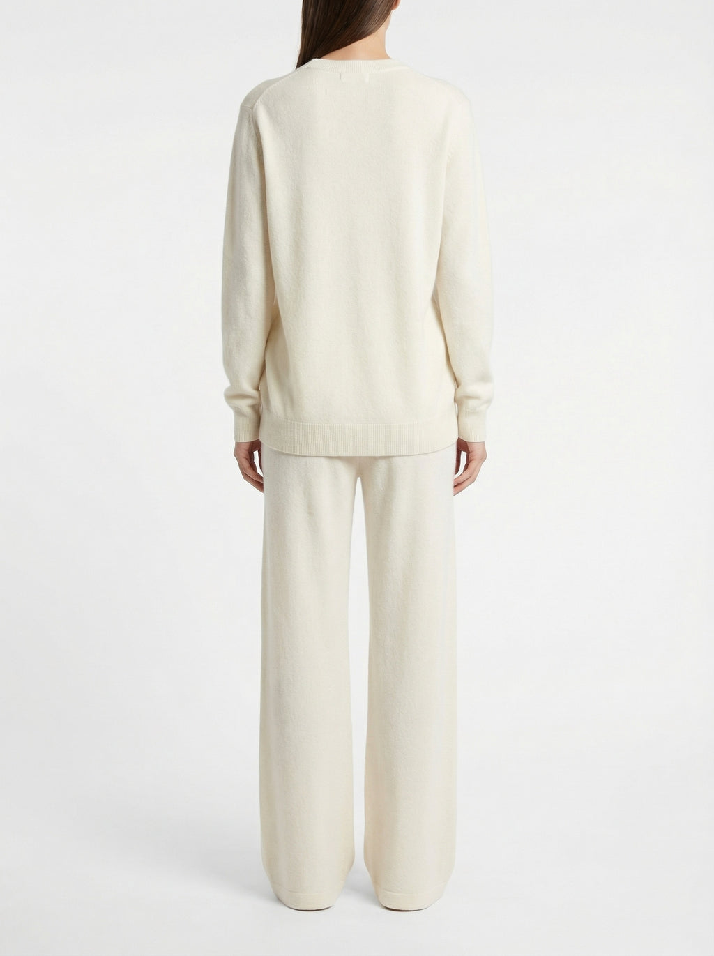 Person wearing a cream-colored outfit on a white background